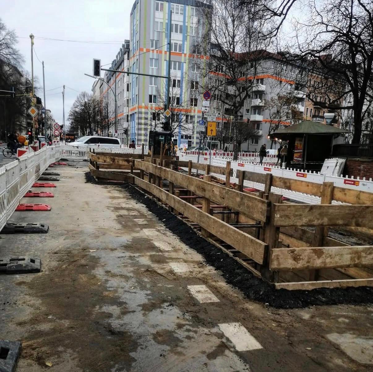 Gesicherte Tiefbaubaustelle mit Holzverbau im Berliner Straßenraum