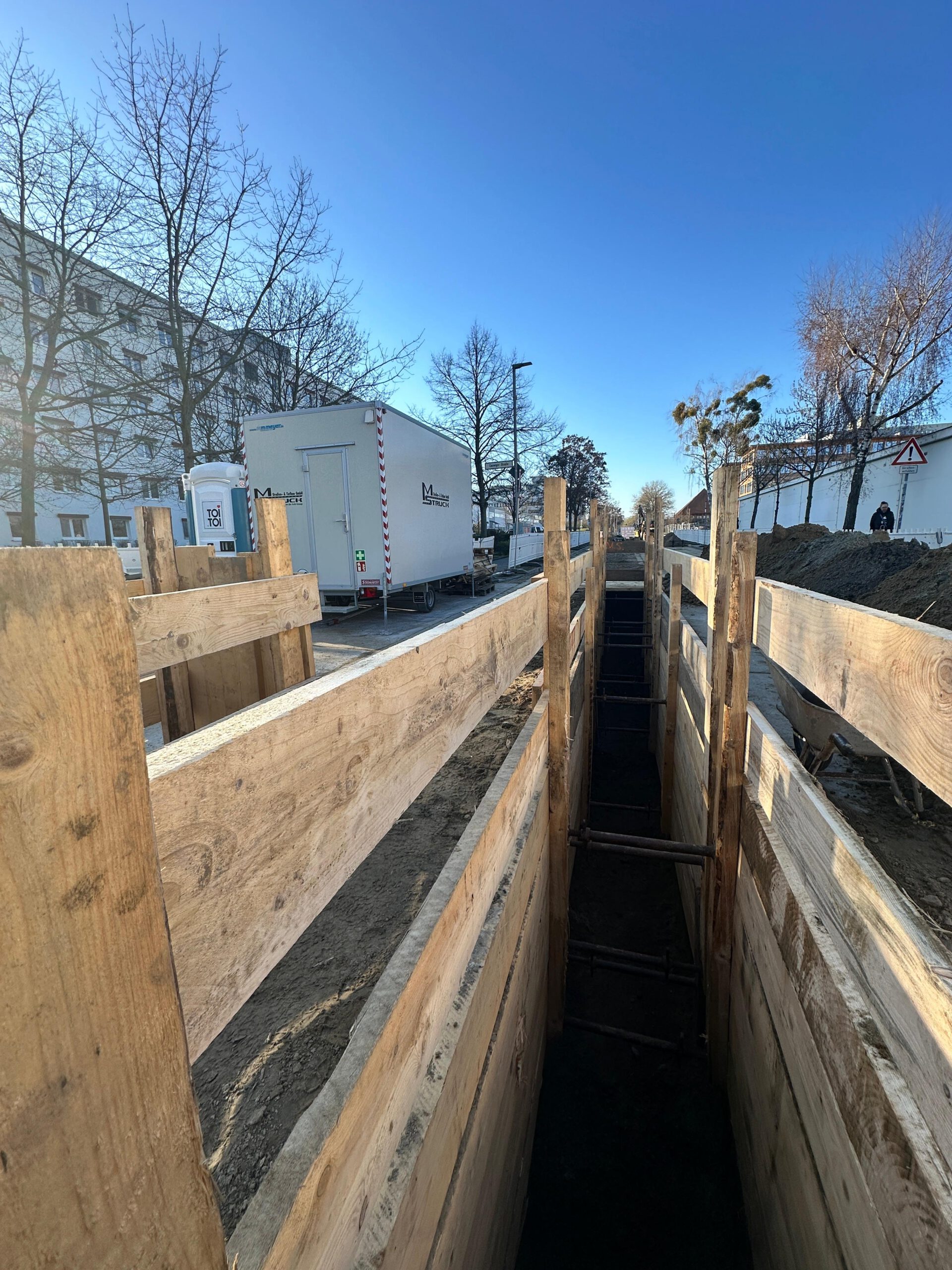 Leitungsgraben mit Holzverbau und MS-Struck-Baustellenwagen